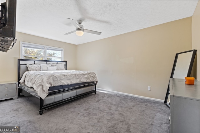 bedroom with a textured ceiling, dark carpet, and ceiling fan