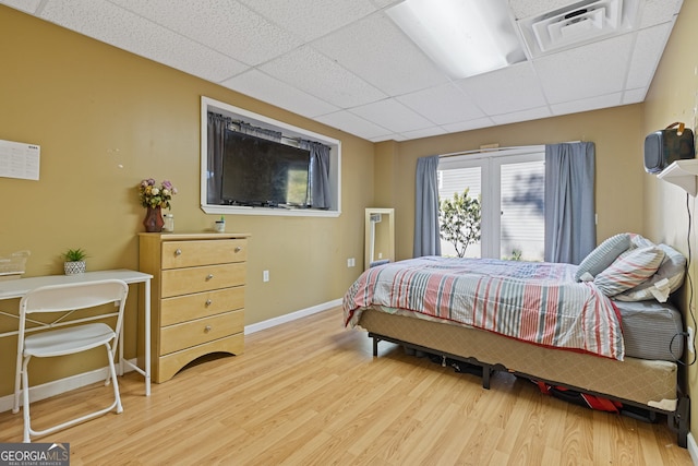 bedroom with hardwood / wood-style flooring and a drop ceiling