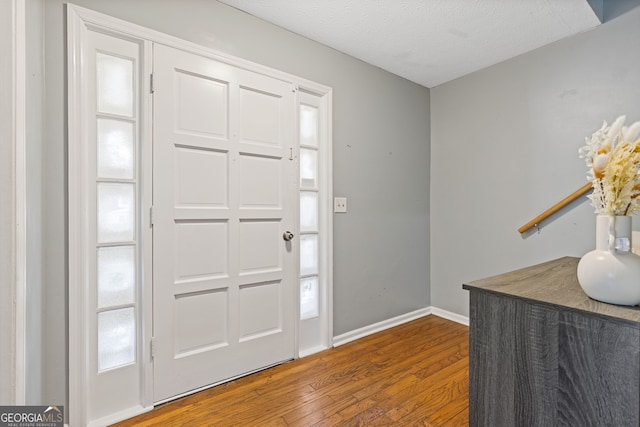 entryway with a textured ceiling and hardwood / wood-style flooring