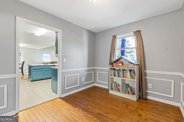 recreation room featuring hardwood / wood-style floors and a textured ceiling