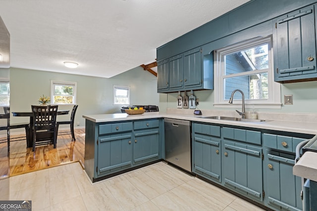 kitchen with kitchen peninsula, light wood-type flooring, stainless steel dishwasher, a textured ceiling, and sink