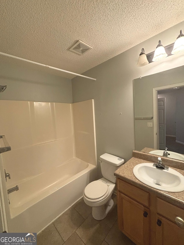 full bathroom with tile patterned flooring, a textured ceiling, toilet, shower / tub combination, and vanity