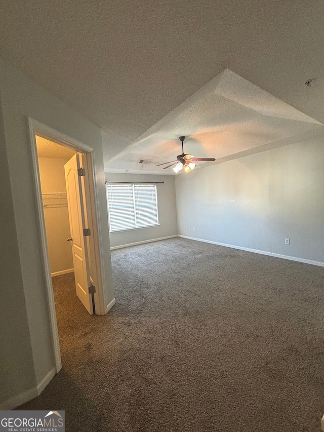 carpeted empty room with ceiling fan and a textured ceiling