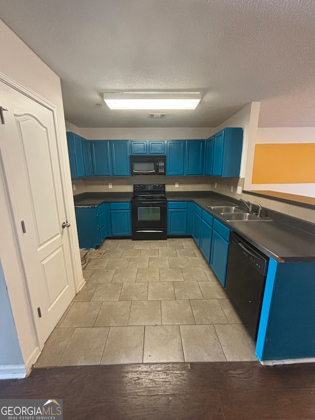 kitchen with sink, black appliances, a textured ceiling, and blue cabinets