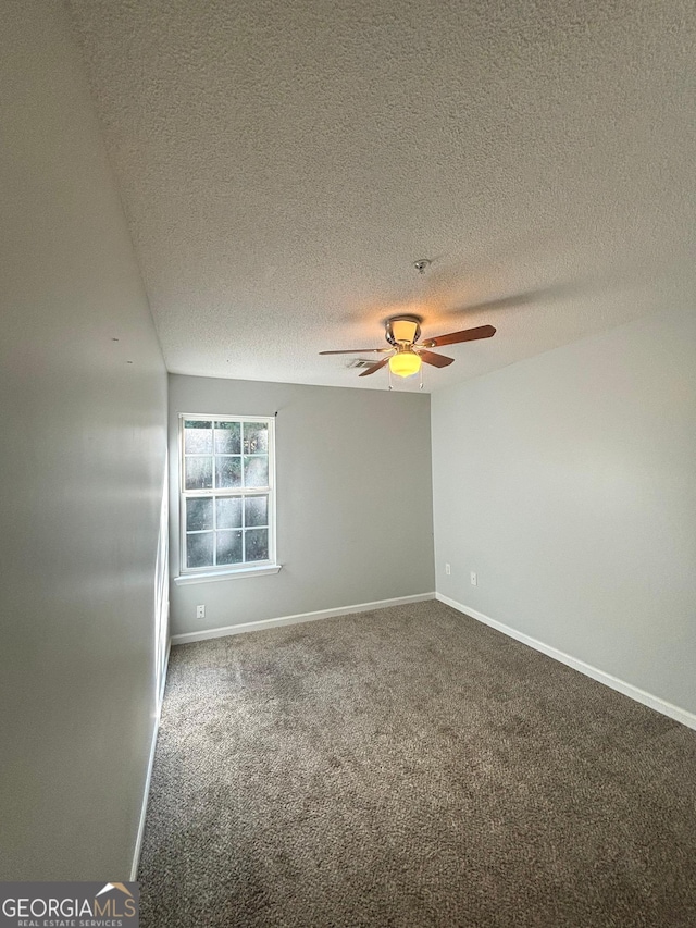 carpeted spare room featuring ceiling fan and a textured ceiling