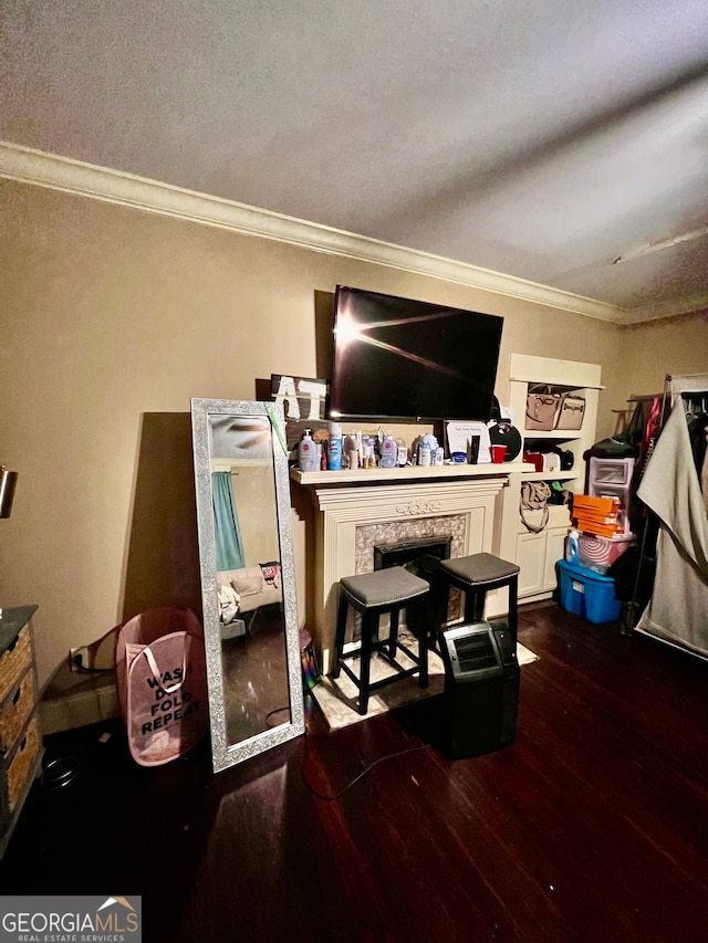 dining space with hardwood / wood-style flooring, crown molding, and a fireplace