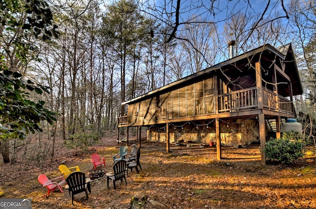 rear view of house featuring a sunroom and a deck