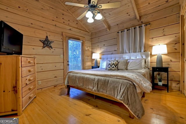 bedroom with lofted ceiling with beams, wooden ceiling, wood walls, and light hardwood / wood-style floors