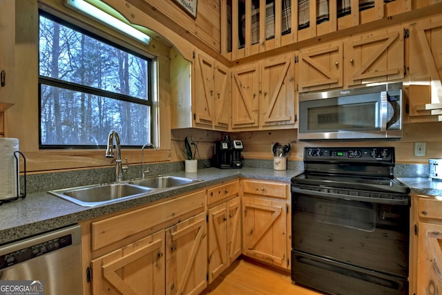 kitchen featuring wood walls, sink, and stainless steel appliances