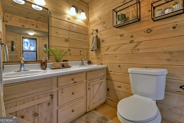 bathroom with vanity, toilet, and wooden walls