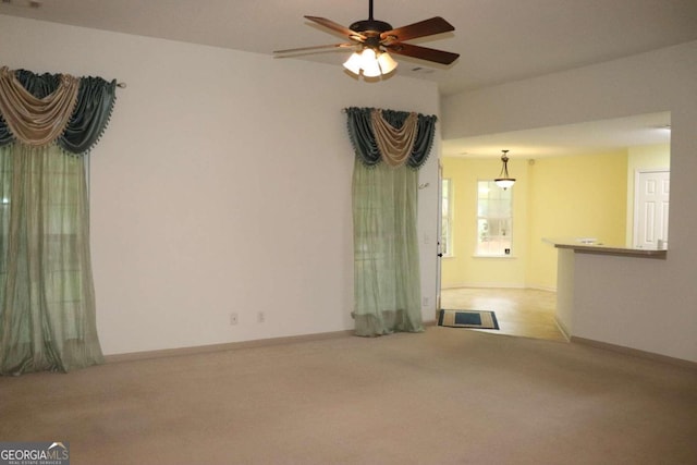 unfurnished living room with ceiling fan and light carpet