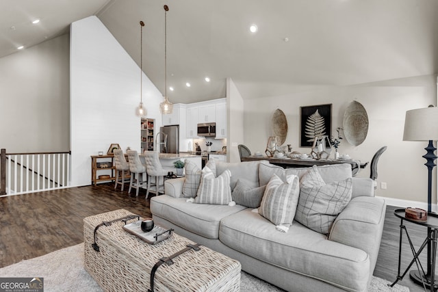 living room with high vaulted ceiling and dark wood-type flooring