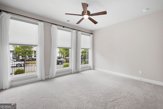 carpeted spare room with ceiling fan