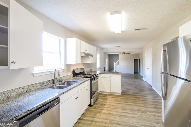 kitchen featuring white cabinetry, sink, stainless steel appliances, and light hardwood / wood-style floors