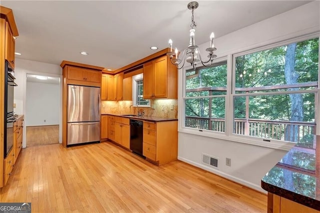 kitchen featuring stainless steel fridge, sink, a notable chandelier, dishwasher, and light hardwood / wood-style floors