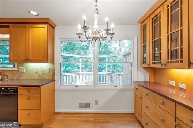 kitchen featuring dishwasher, a healthy amount of sunlight, a notable chandelier, and light hardwood / wood-style floors