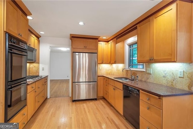 kitchen with sink, light wood-type flooring, tasteful backsplash, and black appliances