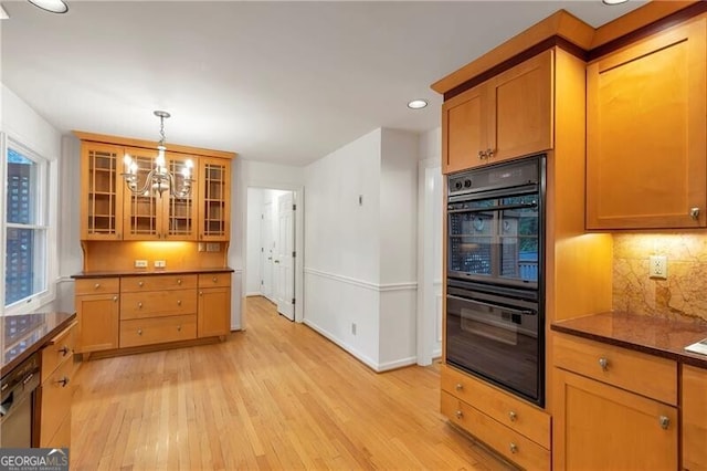 kitchen with double oven, a wealth of natural light, a notable chandelier, and light wood-type flooring