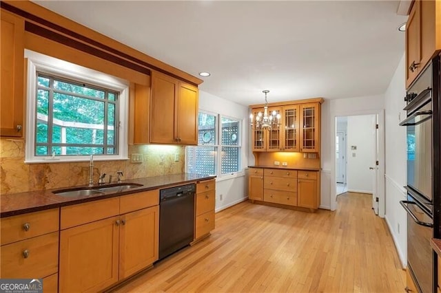 kitchen with light wood-type flooring, tasteful backsplash, sink, decorative light fixtures, and dishwasher