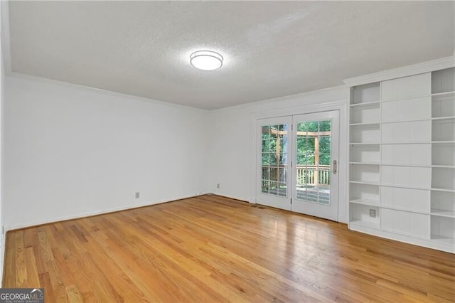 unfurnished room with a textured ceiling and hardwood / wood-style flooring