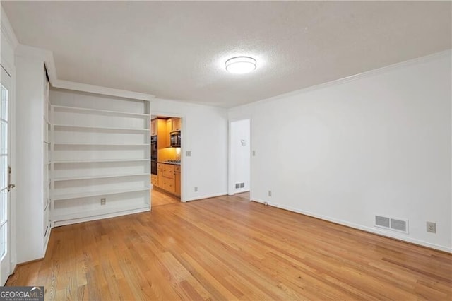 unfurnished bedroom featuring crown molding, a textured ceiling, and light wood-type flooring