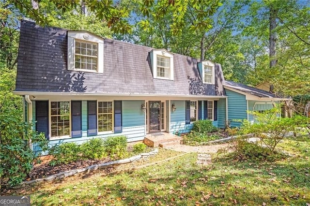 new england style home featuring covered porch and a front yard