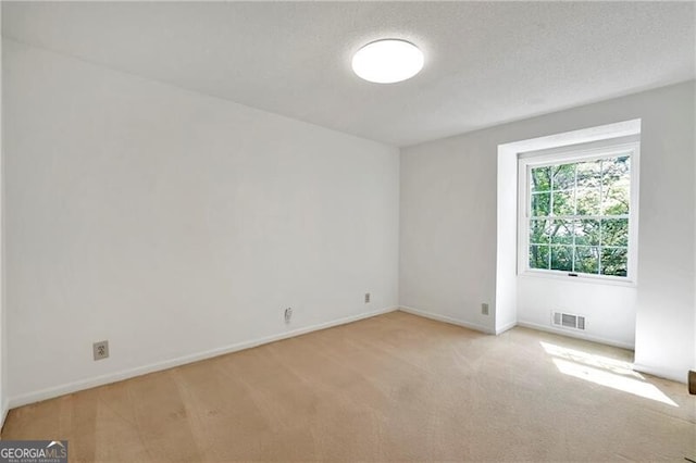 carpeted empty room with a textured ceiling