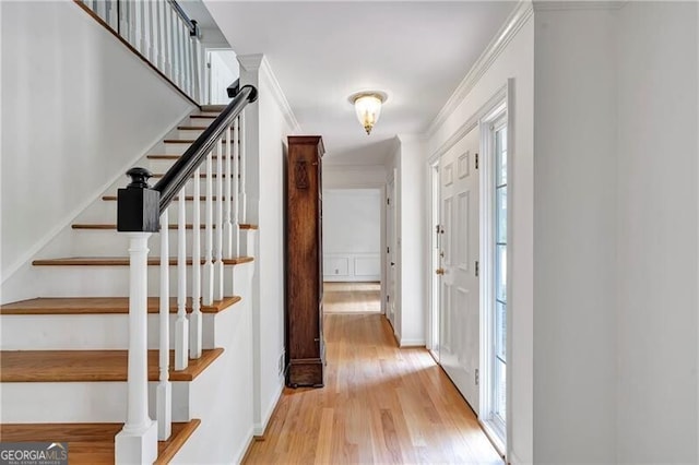 entrance foyer featuring light hardwood / wood-style flooring, plenty of natural light, and crown molding