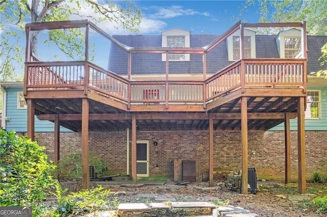 rear view of property featuring a wooden deck