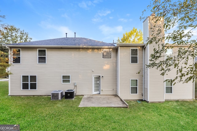 rear view of property with a lawn, a patio area, and central AC