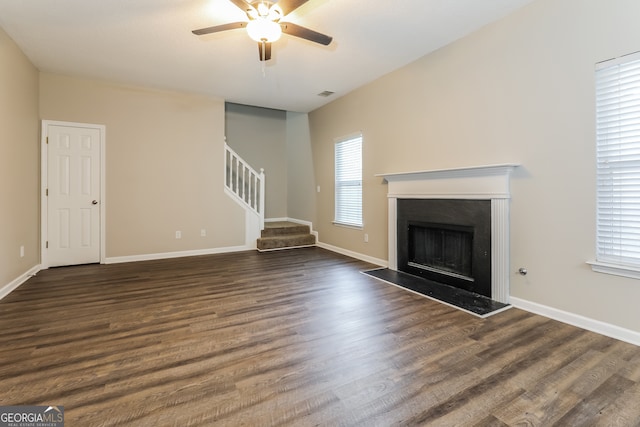 unfurnished living room with ceiling fan, a healthy amount of sunlight, and dark hardwood / wood-style floors