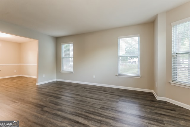 unfurnished room with dark wood-type flooring