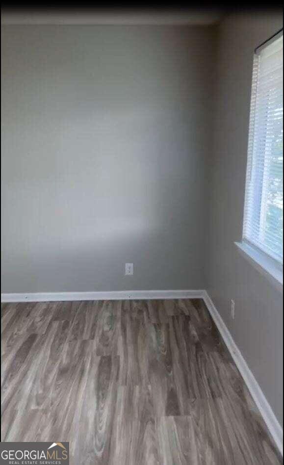 unfurnished room featuring dark wood-type flooring