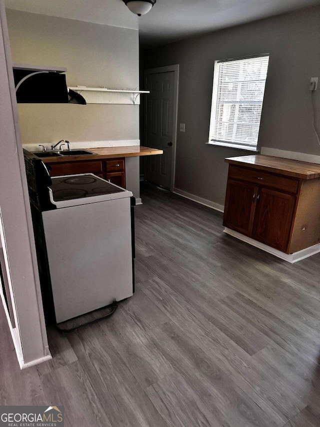 kitchen featuring white range oven, hardwood / wood-style flooring, and sink