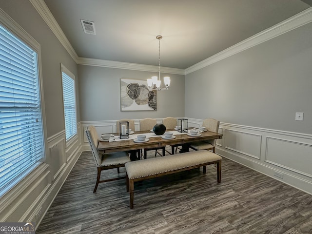 dining room featuring a chandelier, crown molding, and dark wood-type flooring