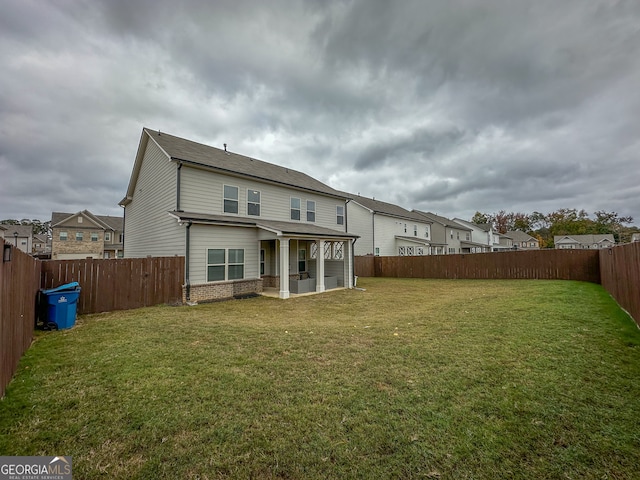 rear view of house featuring a yard