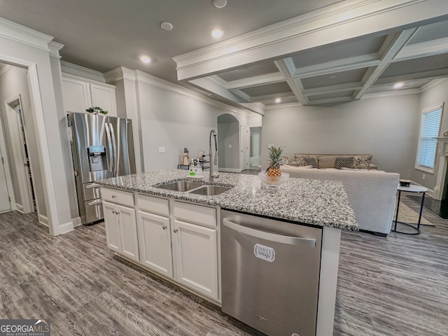 kitchen with sink, an island with sink, light hardwood / wood-style floors, white cabinetry, and stainless steel appliances