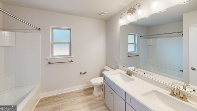 full bathroom with bathtub / shower combination, wood-type flooring, vanity, and toilet