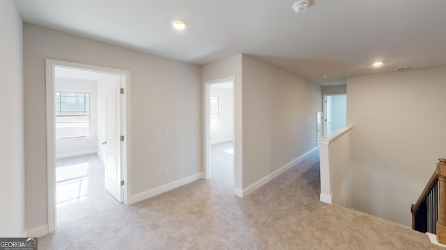 unfurnished bedroom featuring connected bathroom, light carpet, and a closet