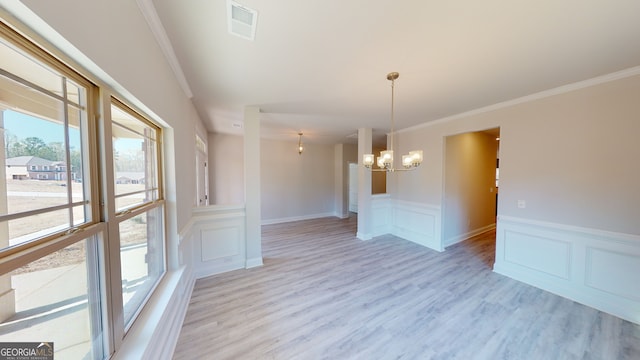 hall featuring light wood-type flooring, crown molding, and a notable chandelier