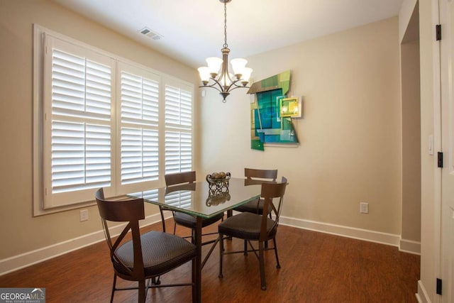 dining area featuring a chandelier and dark wood-type flooring