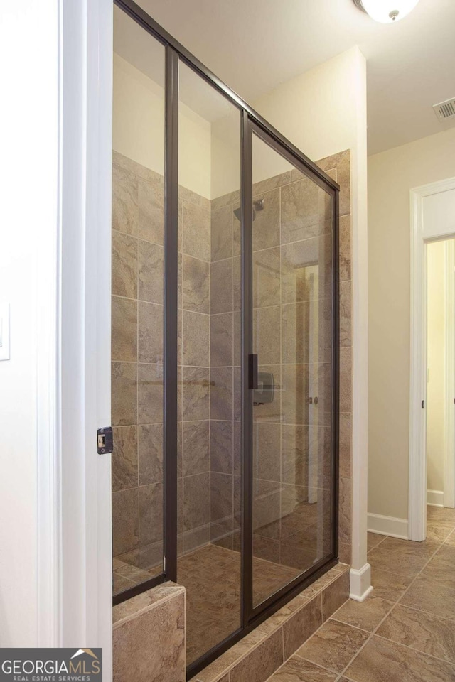 bathroom featuring tile patterned flooring and a shower with shower door