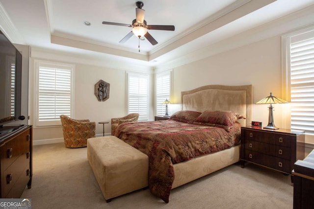 bedroom with a raised ceiling, ceiling fan, light colored carpet, and ornamental molding