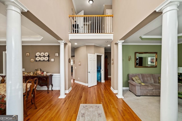 entrance foyer with hardwood / wood-style flooring, a raised ceiling, and ornamental molding