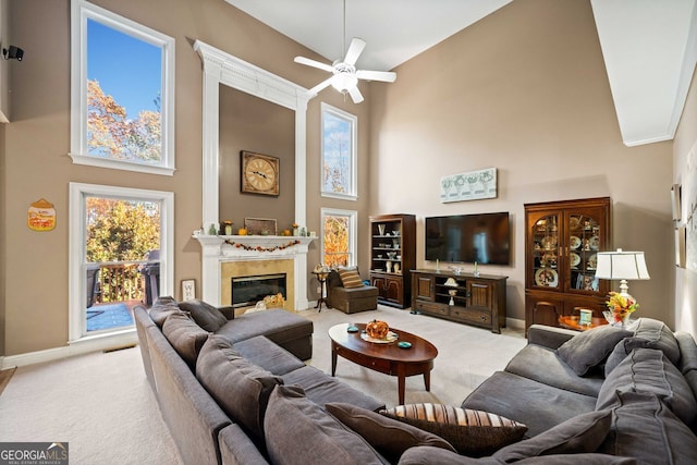 carpeted living room with a high ceiling and ceiling fan