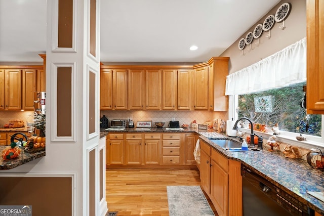 kitchen with tasteful backsplash, dark stone counters, sink, dishwasher, and light hardwood / wood-style floors