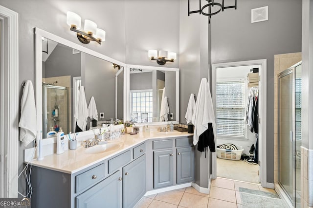 bathroom with tile patterned floors, a shower with shower door, and a healthy amount of sunlight