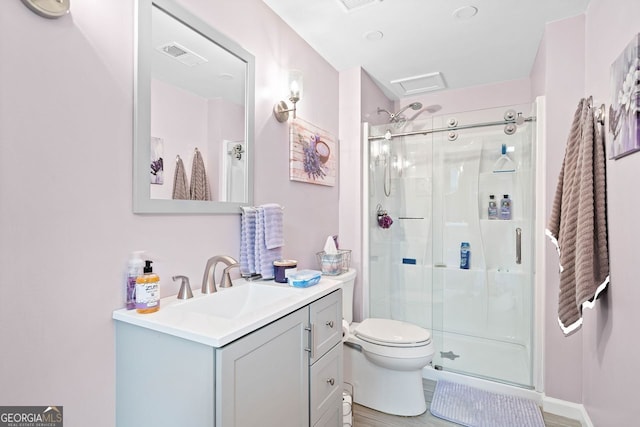 bathroom with vanity, wood-type flooring, an enclosed shower, and toilet