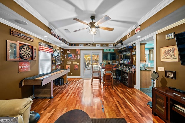 rec room with wood-type flooring, french doors, crown molding, and a healthy amount of sunlight