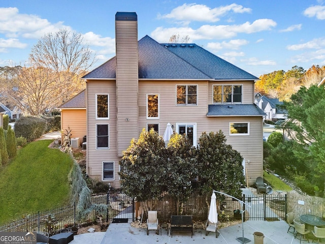 rear view of house with a lawn, a patio, and central AC unit